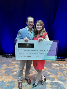 Patty and Knute hold an award check